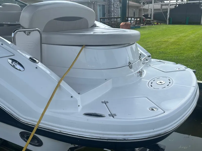 Slide: The Image of 2010 Chaparral 275 SSi boat, white exterior, docked near grassy area. - 4