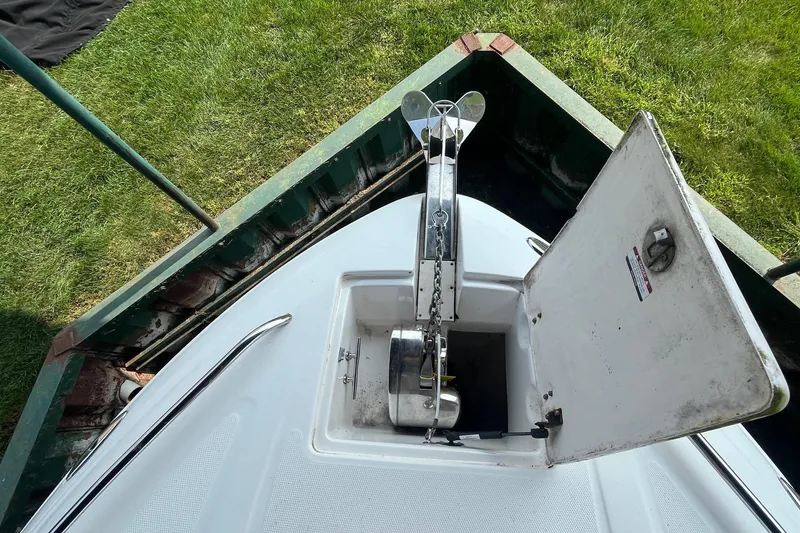 Slide: The Image of 2010 Chaparral 275 SSi boat anchor compartment open, showing anchor and chain mechanism. - 6