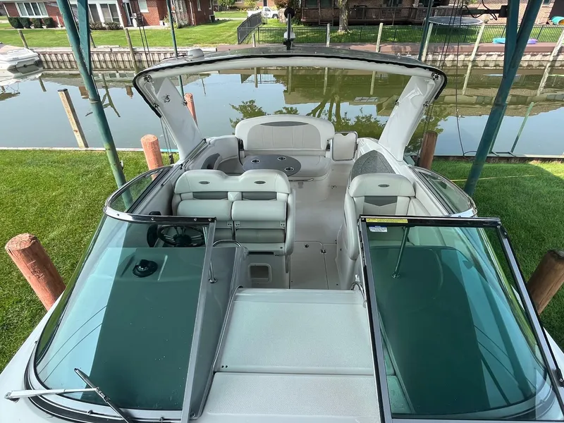 Slide: The Image of 2010 Chaparral 275 SSi boat with open cockpit and seating, docked by a canal. - 8