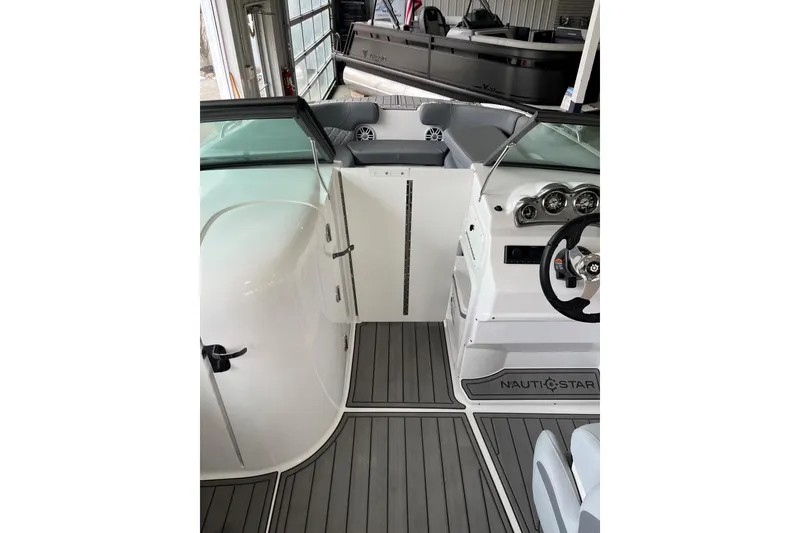 Slide: The Image of 2025 NauticStar 223 DC Deck boat interior with sleek design and modern dashboard. - 14