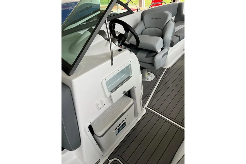 Slide: The Image of 2025 NauticStar 223 DC Deck boat interior with steering wheel and seating. - 16