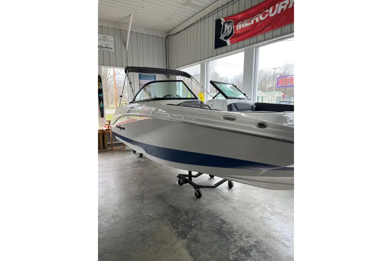 Slide: The Image of 2025 NauticStar 223 DC Deck boat displayed indoors, showcasing sleek design and modern features. - 17