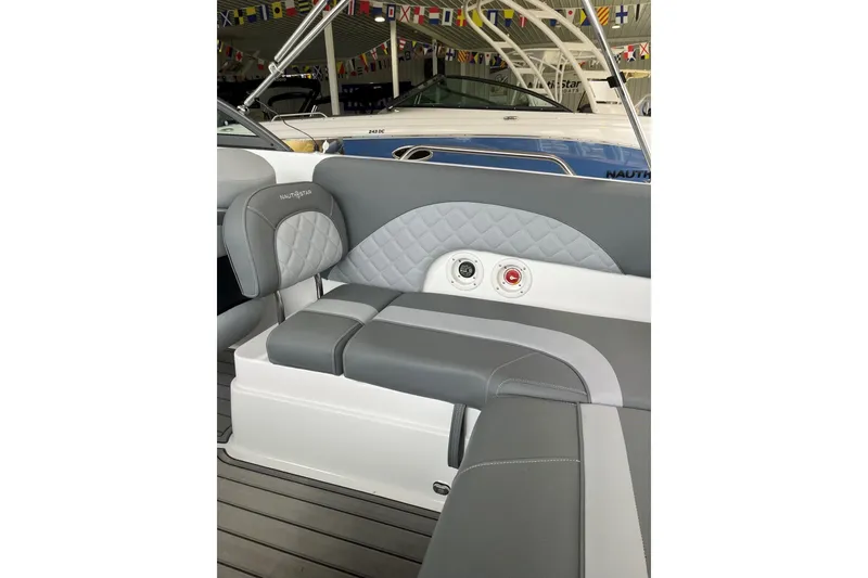 Slide: The Image of 2025 NauticStar 223 DC Deck boat interior with gray seating and quilted design. - 18