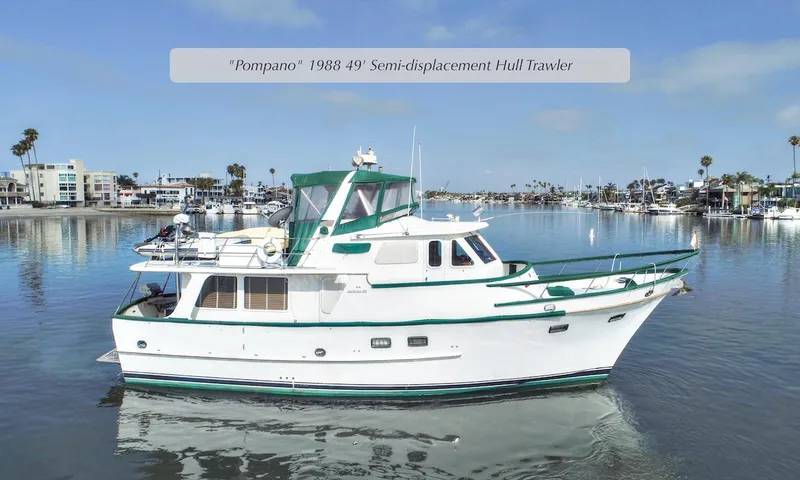 The Image of 1988 DeFever Pilot House yacht on calm water, semi-displacement hull, green accents, coastal background. - 1