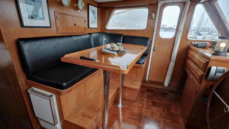 Slide: The Image of 1988 DeFever Pilot House interior with wooden dining area and black seating. - 11
