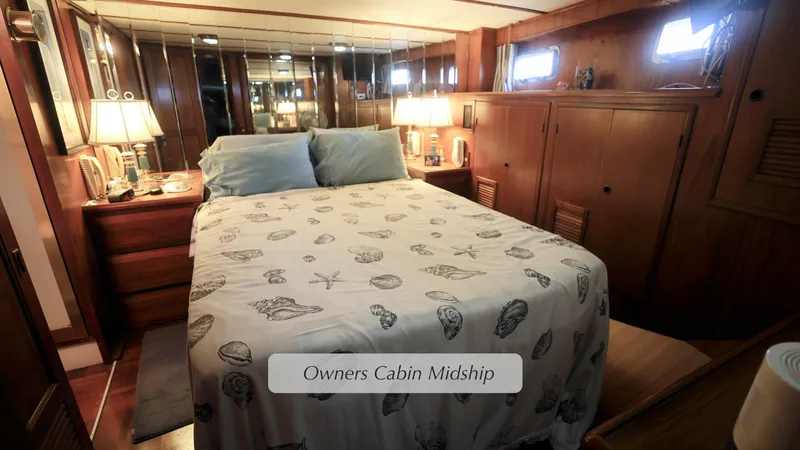 Slide: The Image of 1988 DeFever Pilot House owner's cabin midship with cozy bed and wooden furnishings. - 13