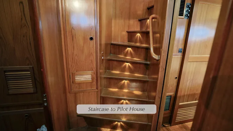 Slide: The Image of Staircase in 1988 DeFever Pilot House with wooden interior and ambient lighting. - 17