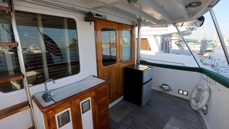 Slide: The Image of 1988 DeFever Pilot House yacht deck with wooden doors, sink, and marina view. - 18