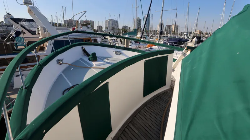 Slide: The Image of 1988 DeFever Pilot House yacht with green accents docked in a marina. - 20