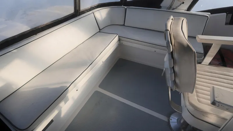 Slide: The Image of 1988 DeFever Pilot House interior with white seating and captain's chair. - 24
