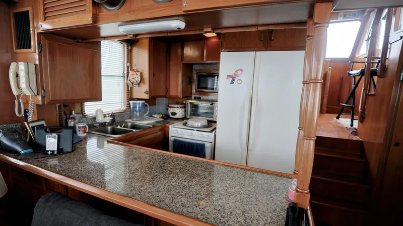 Slide: The Image of 1988 DeFever Pilot House kitchen with granite countertop and wooden cabinetry. - 8