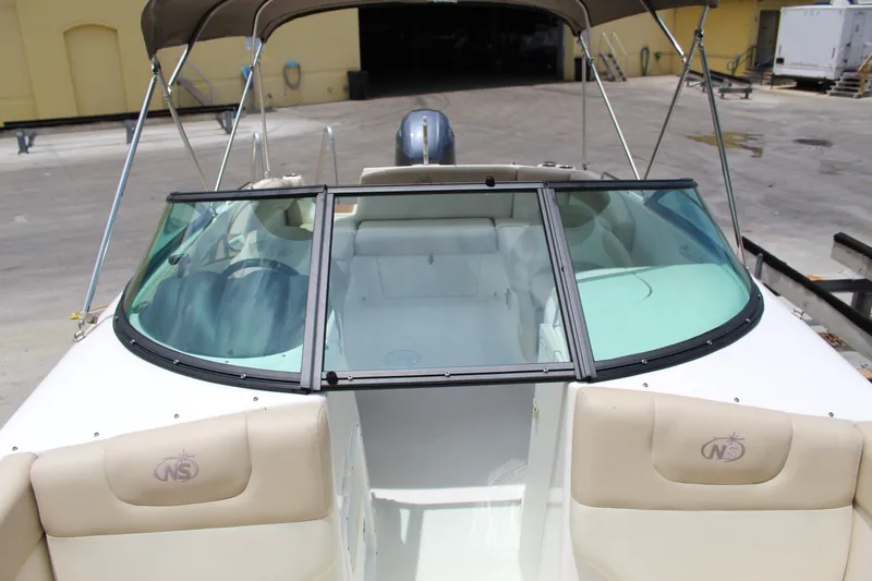 Slide: The Image of 2017 NauticStar 243DC Sport Deck boat with beige seating and windshield. - 13