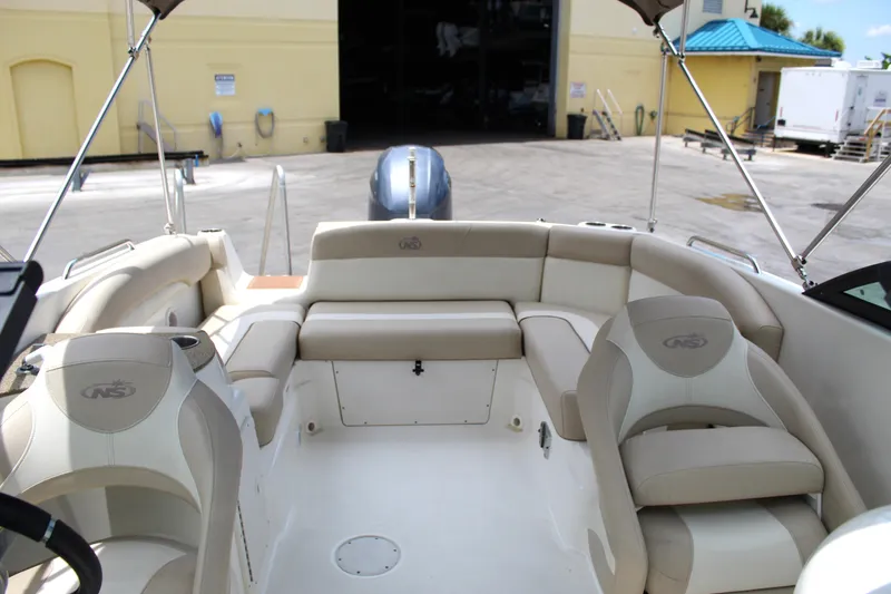 Slide: The Image of 2017 NauticStar 243DC Sport Deck boat interior with beige seating and open deck. - 14