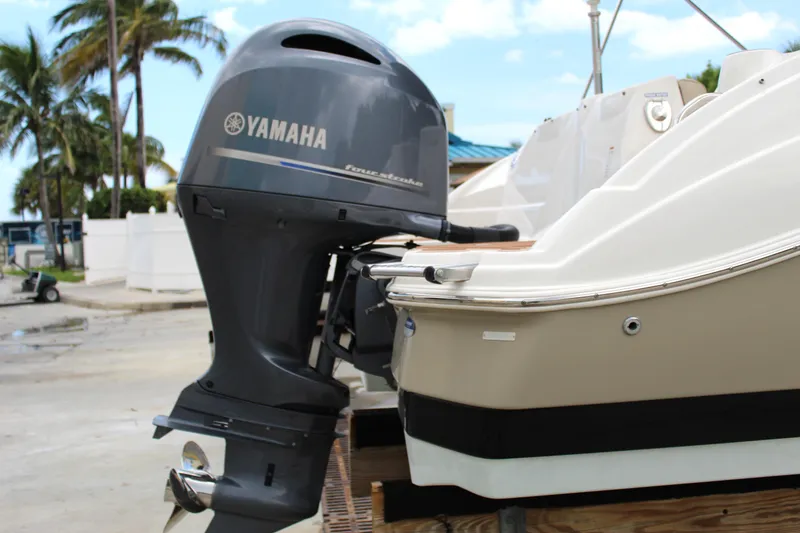 Slide: The Image of 2017 NauticStar 243DC Sport Deck with Yamaha outboard motor, docked near palm trees. - 15