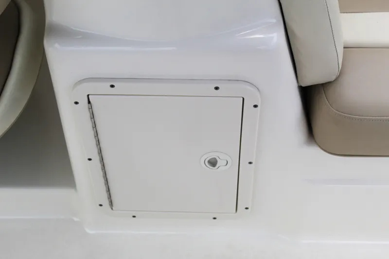 Slide: The Image of 2017 NauticStar 243DC Sport Deck storage compartment with beige seating. - 19