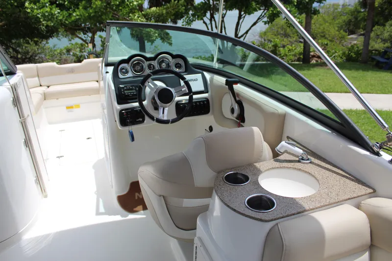 Slide: The Image of 2017 NauticStar 243DC Sport Deck boat interior with steering wheel and seating area. - 20