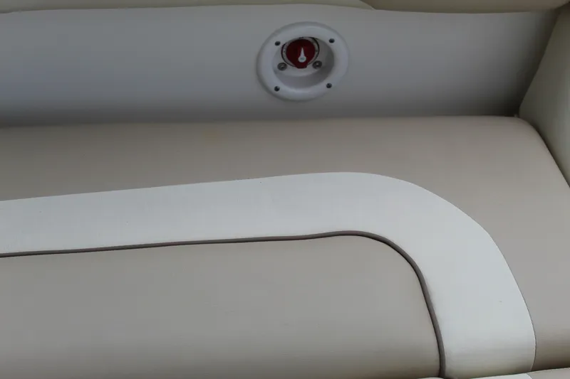 Slide: The Image of 2017 NauticStar 243DC Sport Deck boat seat with beige upholstery and red control knob. - 30