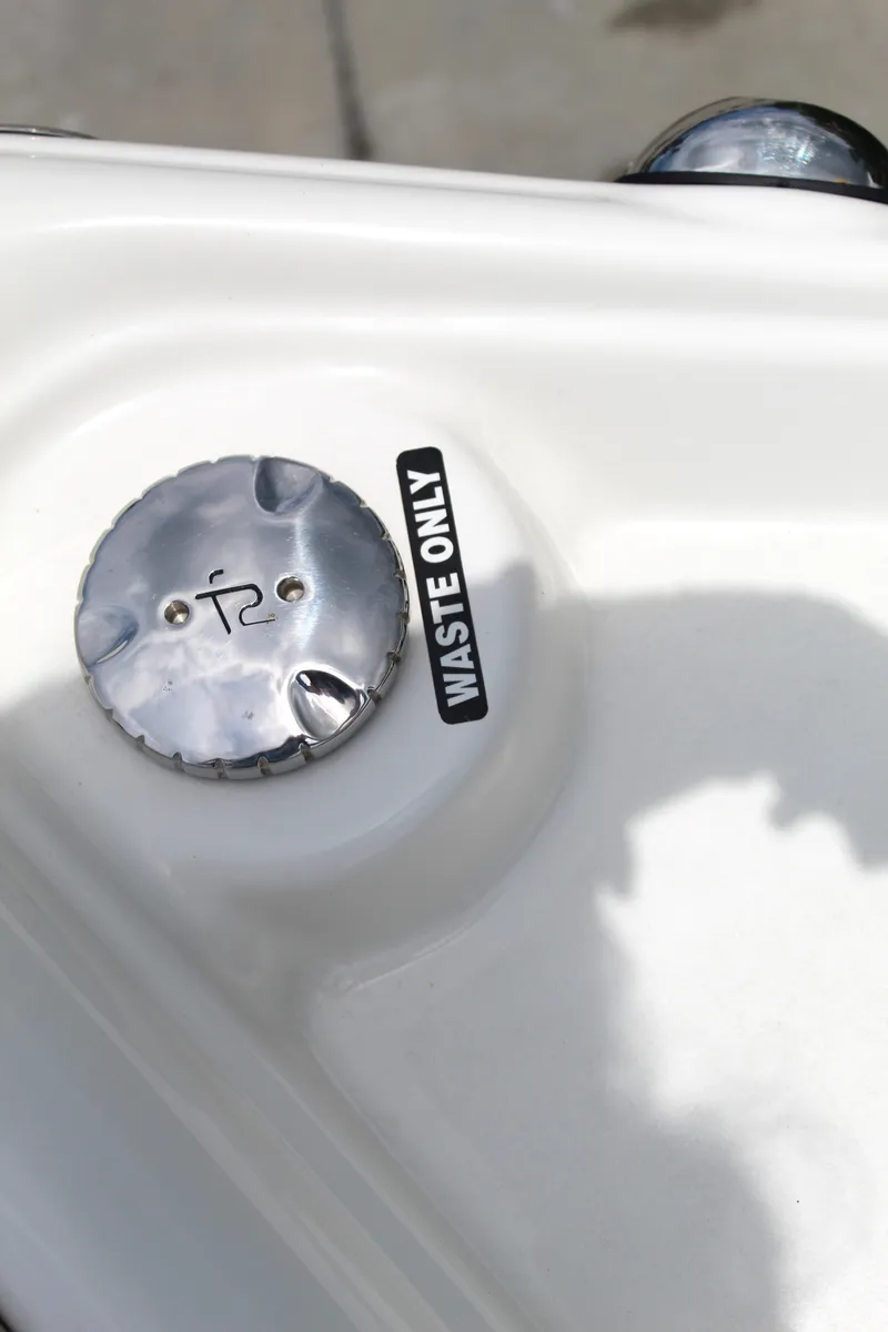 Slide: The Image of 2017 NauticStar 243DC Sport Deck waste cap labeled "Waste Only." - 49