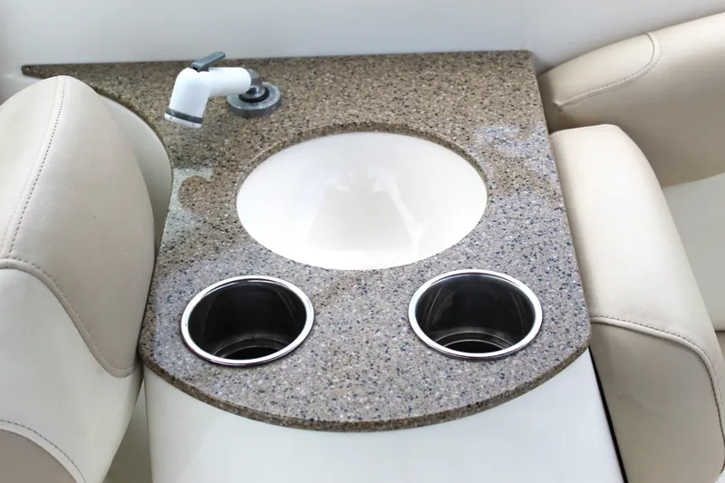 Slide: The Image of 2017 NauticStar 243DC Sport Deck boat sink with granite countertop and cup holders. - 6