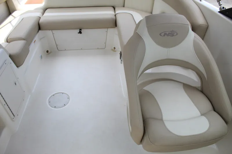 Slide: The Image of 2017 NauticStar 243DC Sport Deck interior with beige seating and spacious layout. - 8