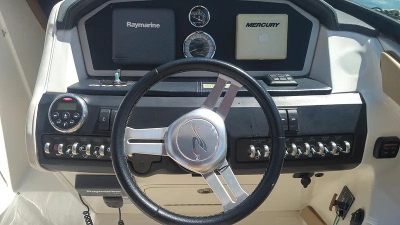 Slide: The Image of 2014 Sea Ray 300 SLX boat dashboard with steering wheel and control panel. - 17