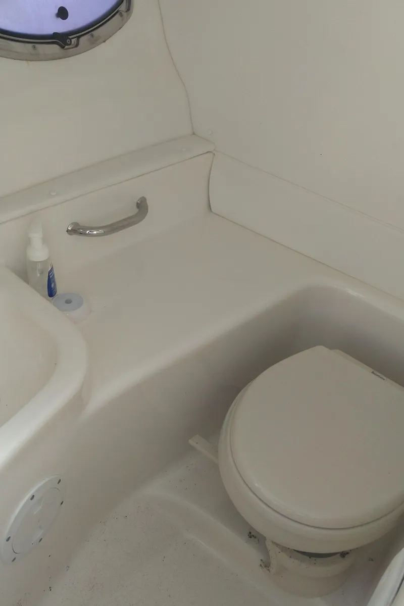 Slide: The Image of 2014 Sea Ray 300 SLX boat bathroom interior with toilet and porthole. - 24