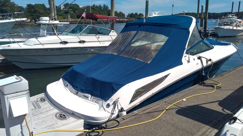 Slide: The Image of 2014 Sea Ray 300 SLX boat docked with blue cover in marina. - 4