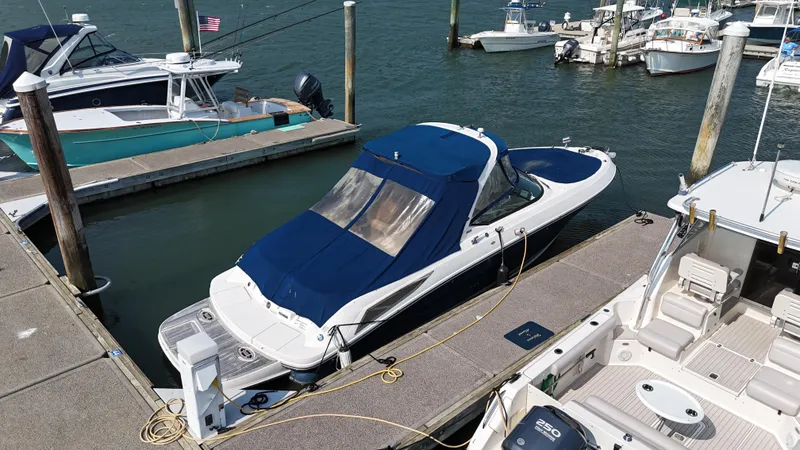 Slide: The Image of 2014 Sea Ray 300 SLX boat docked at marina with blue cover. - 47