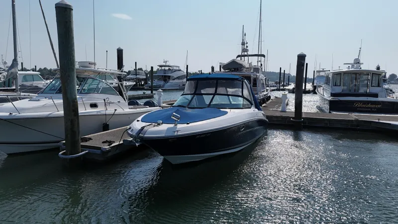 Slide: The Image of 2014 Sea Ray 300 SLX boat docked in a marina under clear skies. - 49