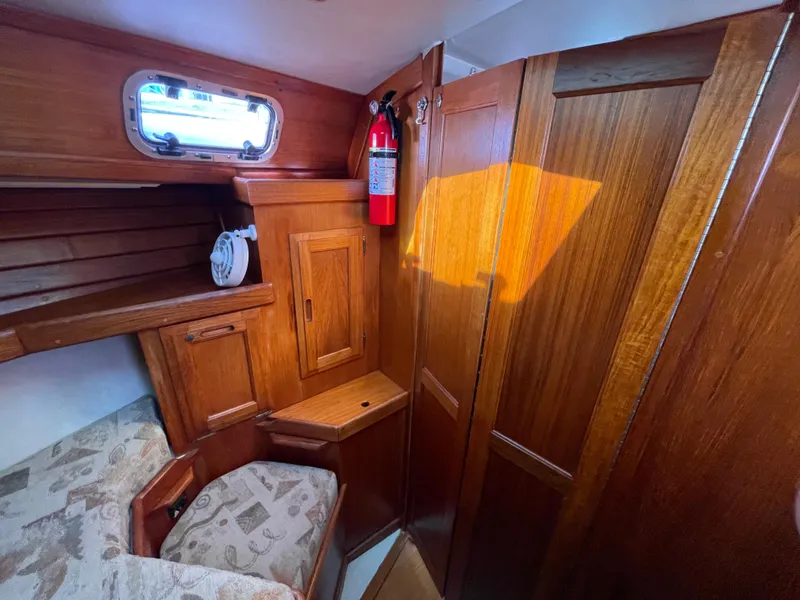 Slide: The Image of 1990 Ericson 38-200 yacht interior with wooden cabinetry and seating area. - 15