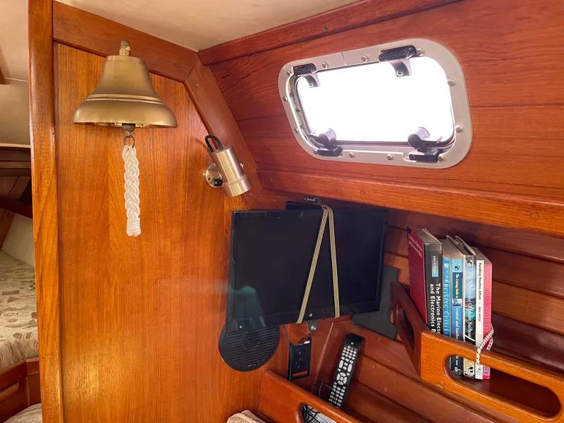 Slide: The Image of Interior of 1990 Ericson 38-200 sailboat with books, bell, and porthole. - 18
