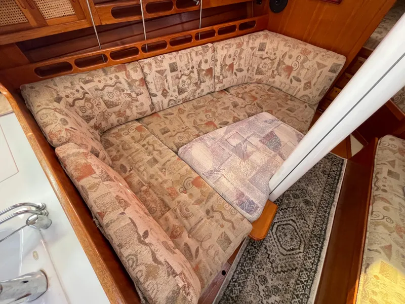 Slide: The Image of Cozy seating area in 1990 Ericson 38-200 sailboat with patterned cushions and wooden accents. - 20