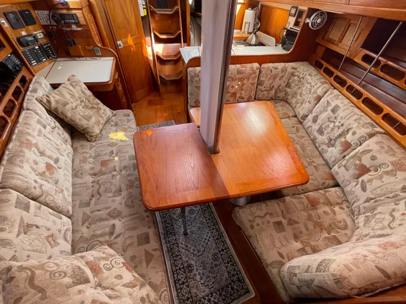 Slide: The Image of Cozy interior of 1990 Ericson 38-200 sailboat with cushioned seating and wooden table. - 21