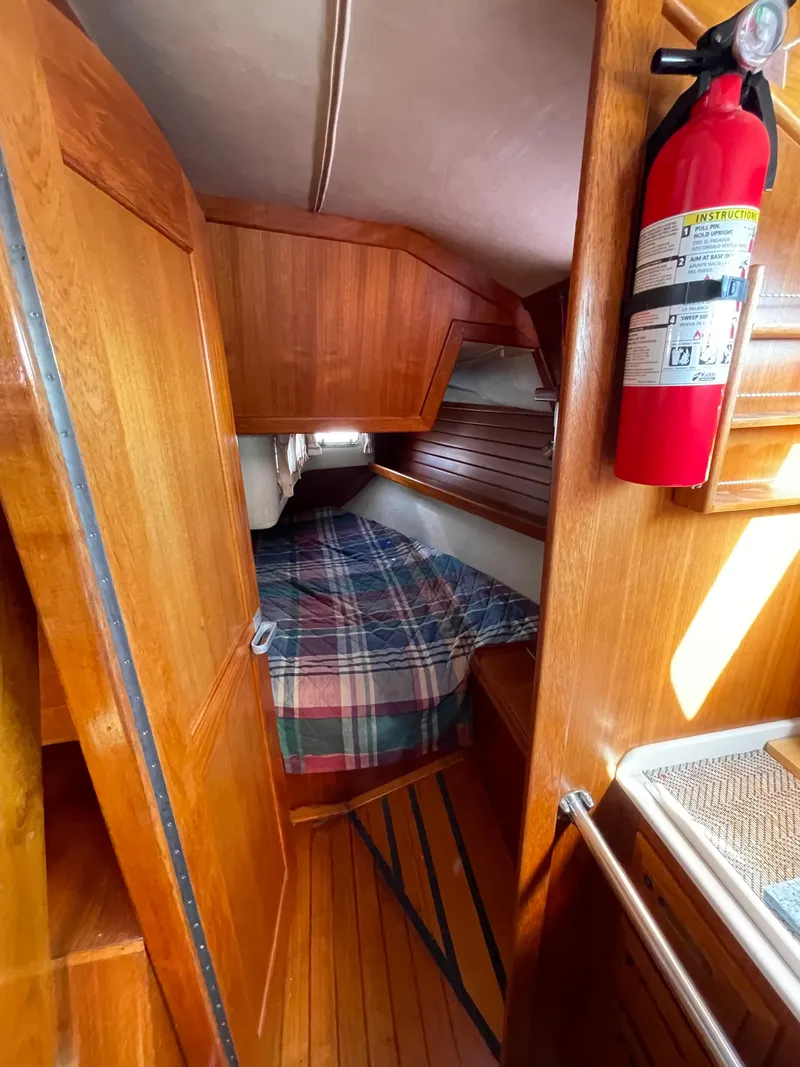 Slide: The Image of Cozy cabin interior of 1990 Ericson 38-200 sailboat with wooden finish and plaid bedding. - 25