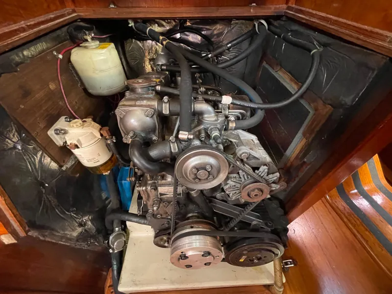 Slide: The Image of Engine compartment of a 1990 Ericson 38-200 sailboat, showcasing mechanical components and hoses. - 30