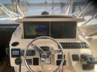 Slide: The Image of 2013 Grady-White 330 Express boat helm with navigation screens and controls. - 11