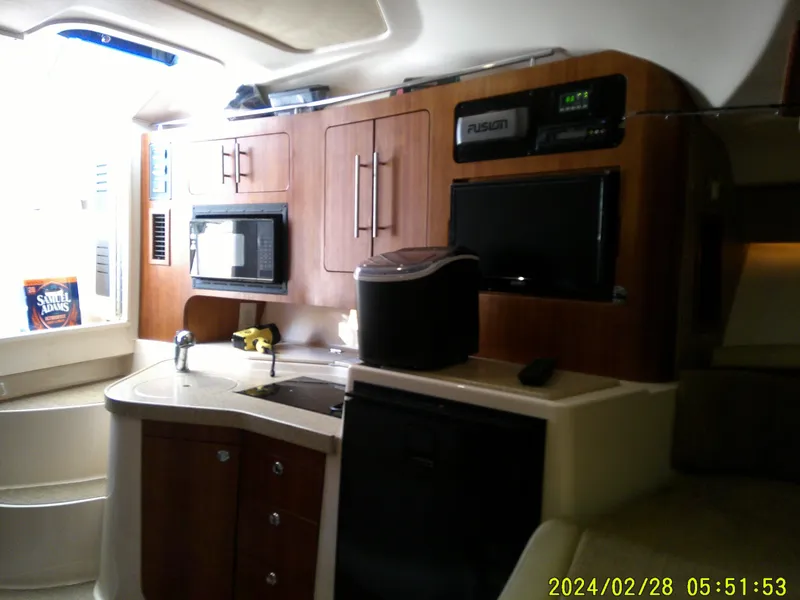 Slide: The Image of Interior of 2013 Grady-White 330 Express boat with kitchen appliances and wooden cabinetry. - 15