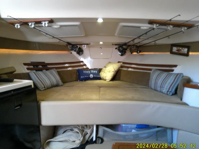 Slide: The Image of 2013 Grady-White 330 Express cabin interior with cozy seating and fishing rods. - 17
