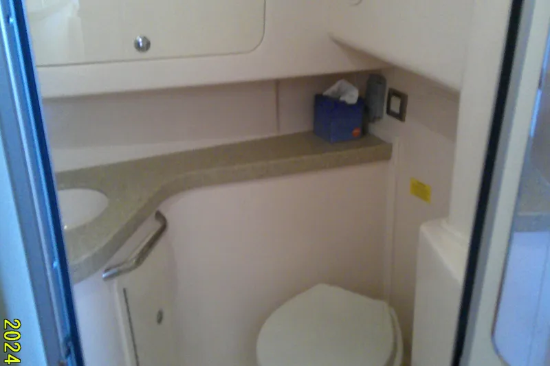 Slide: The Image of 2013 Grady-White 330 Express boat bathroom interior with sink and toilet. - 18