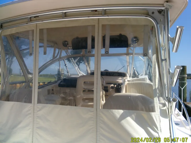 Slide: The Image of 2013 Grady-White 330 Express boat interior with clear enclosure and helm view. - 5