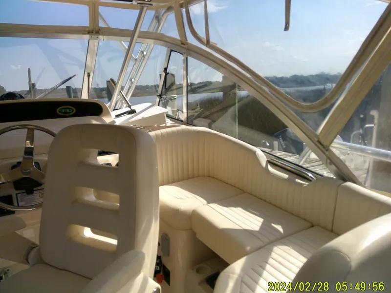 Slide: The Image of Interior of 2013 Grady-White 330 Express boat with beige seating and steering wheel. - 9