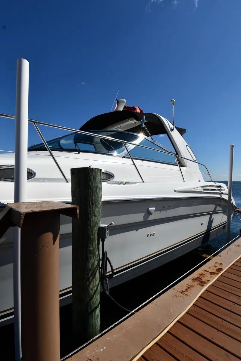 Slide: The Image of 1997 Sea Ray 400 Sundancer yacht docked under clear blue sky. - 1