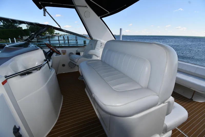 Slide: The Image of 1997 Sea Ray 400 Sundancer cockpit with white seating, overlooking serene ocean view. - 16
