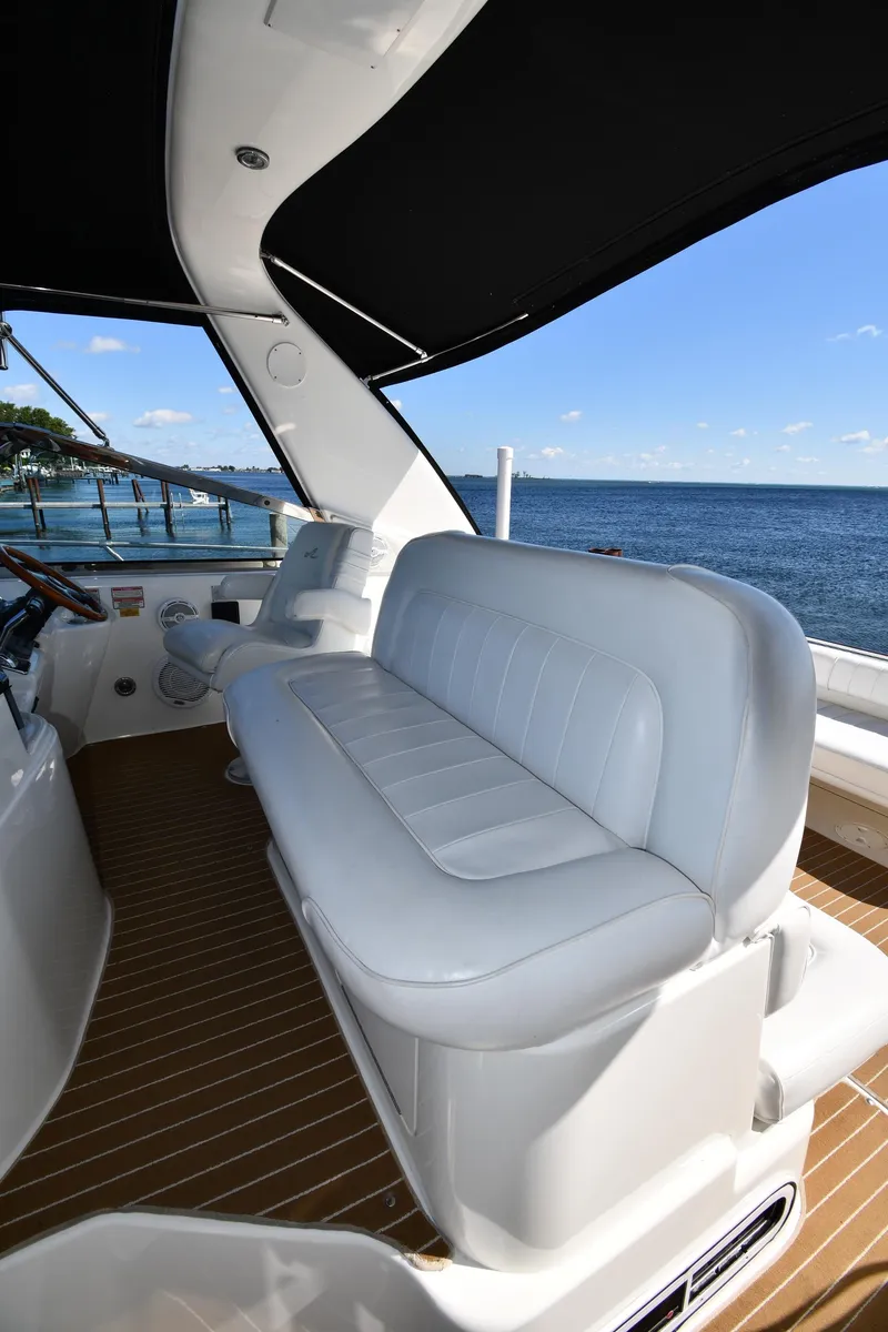 Slide: The Image of 1997 Sea Ray 400 Sundancer yacht interior with white seating and ocean view. - 17