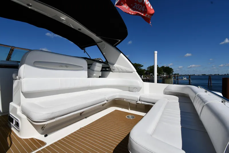 Slide: The Image of Spacious deck of 1997 Sea Ray 400 Sundancer yacht with white seating and scenic water view. - 18