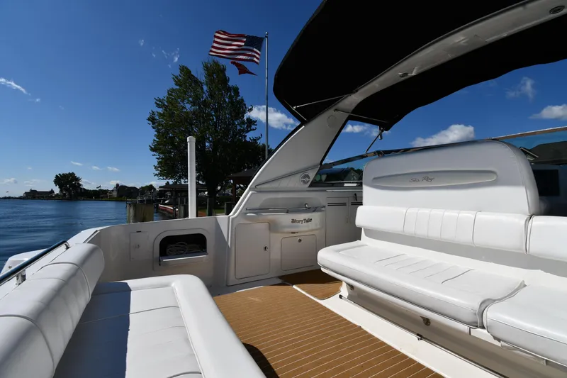 Slide: The Image of 1997 Sea Ray 400 Sundancer yacht with white seating, American flag, and scenic water view. - 20