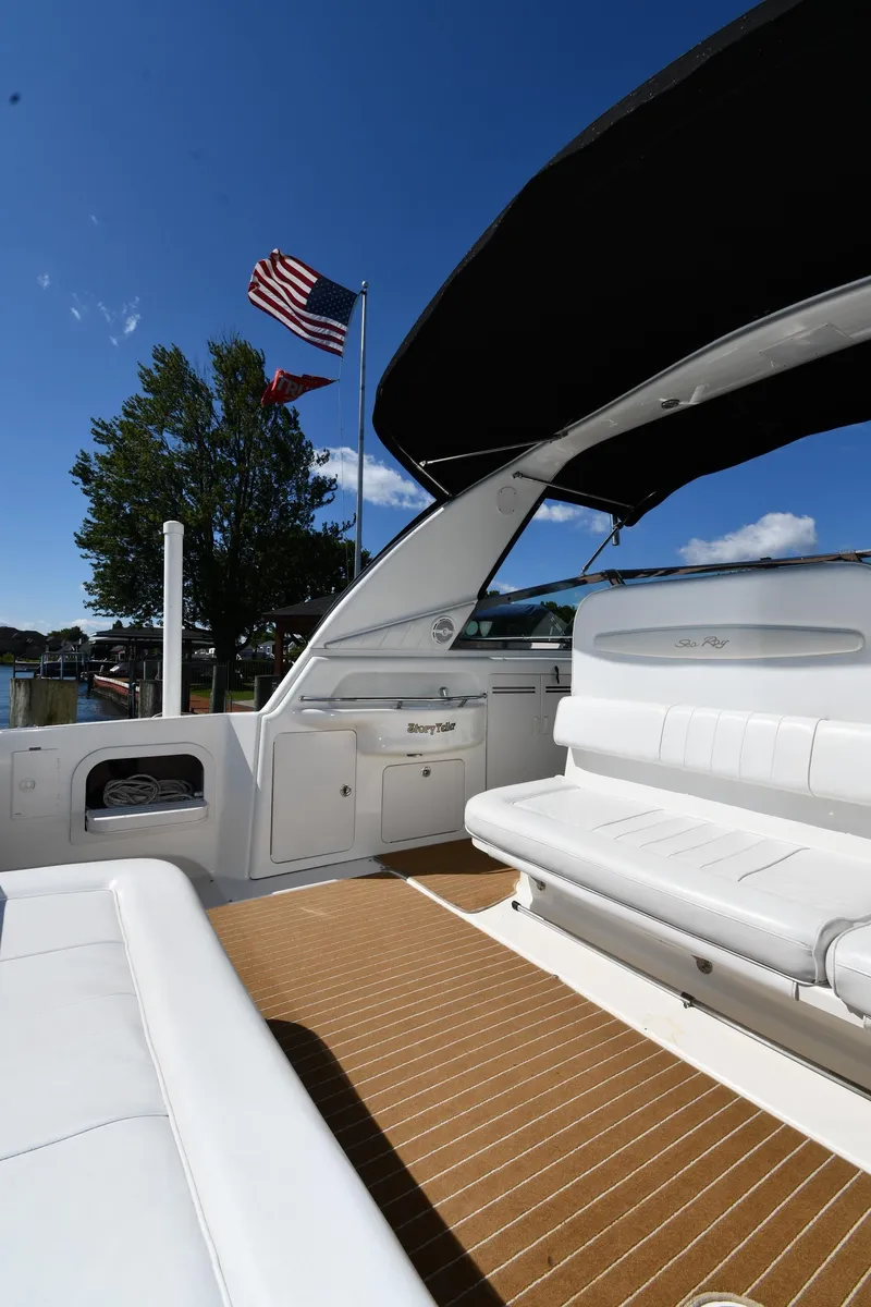 Slide: The Image of 1997 Sea Ray 400 Sundancer yacht with white seating and American flag in background. - 21