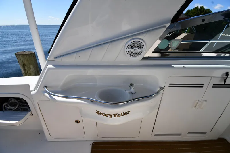 Slide: The Image of 1997 Sea Ray 400 Sundancer yacht interior with sink and storage, docked by the water. - 24