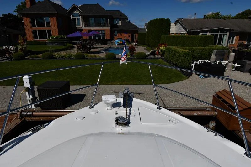 Slide: The Image of Bow view of 1997 Sea Ray 400 Sundancer docked near a luxurious waterfront home. - 3