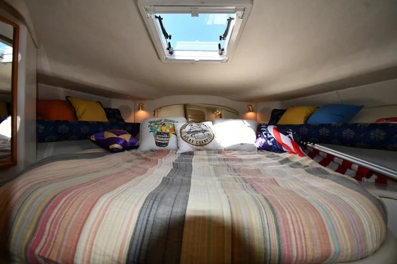 Slide: The Image of Cozy cabin interior of 1997 Sea Ray 400 Sundancer with skylight and colorful bedding. - 30